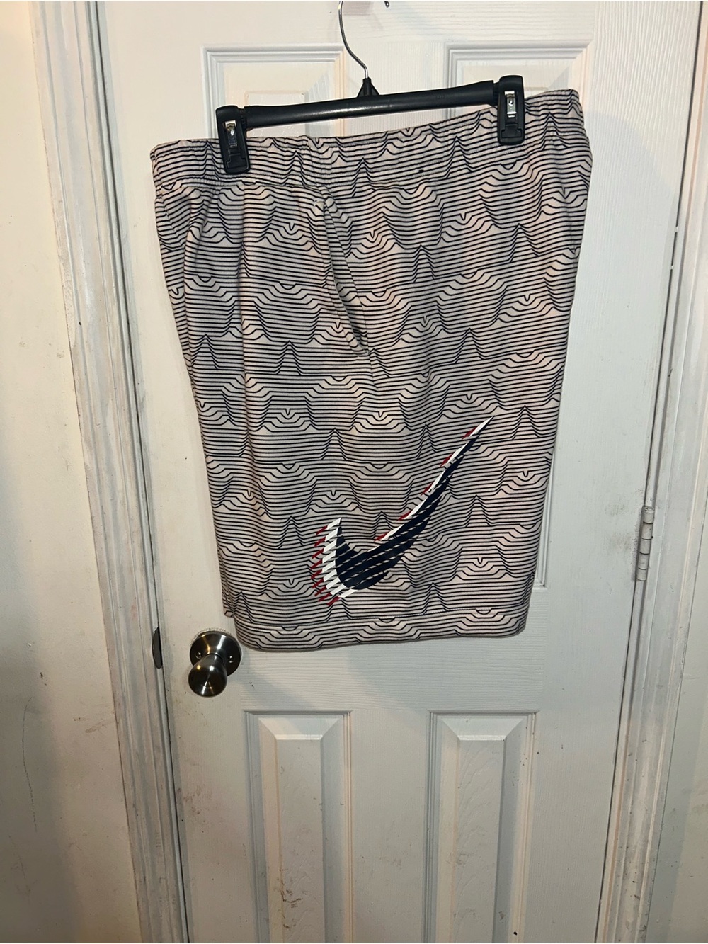 Nike Beige Shorts with Black and Red Swoosh Graphic